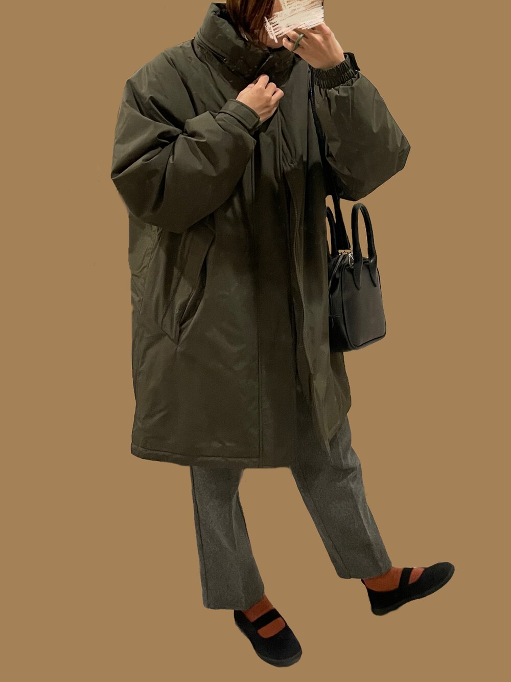 グレー系のその他パンツ、グリーン系のジャケット/アウター、ブラック系のスニーカーを着用したレディースの冬コーディネートの2枚目の写真