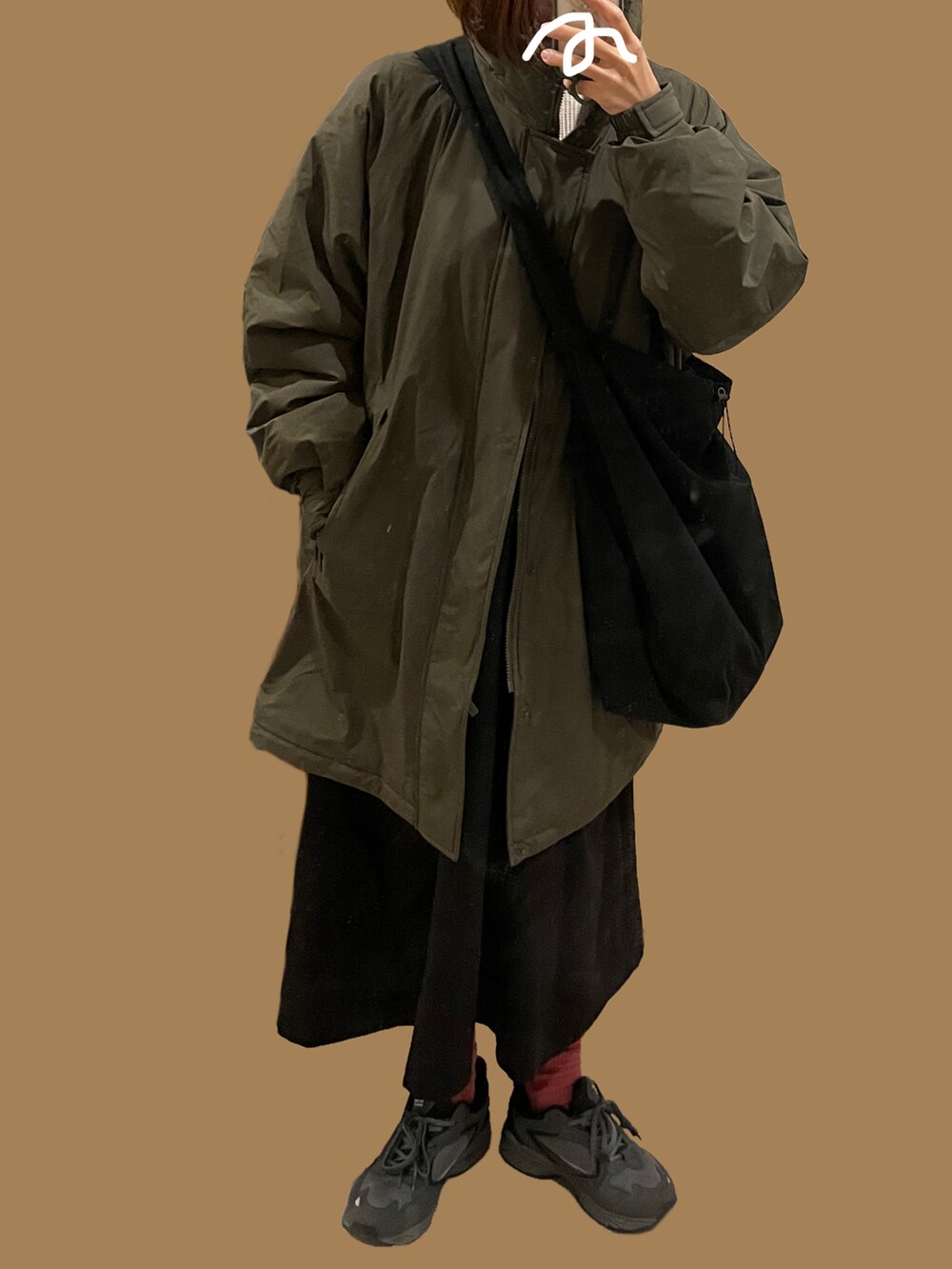 ブラック系のスニーカー、グリーン系のジャケット/アウター、ブラック系のワンピースを着用したレディースの冬コーディネートの2枚目の写真