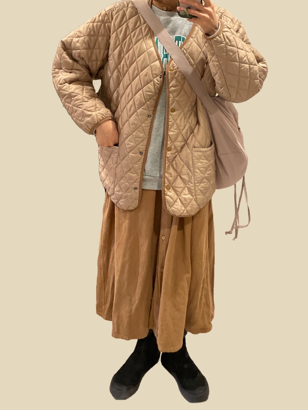 ブラウン系のワンピース、ブラック系のブーツ、ベージュ系のブルゾンを着用したレディースの冬コーディネートの2枚目の写真