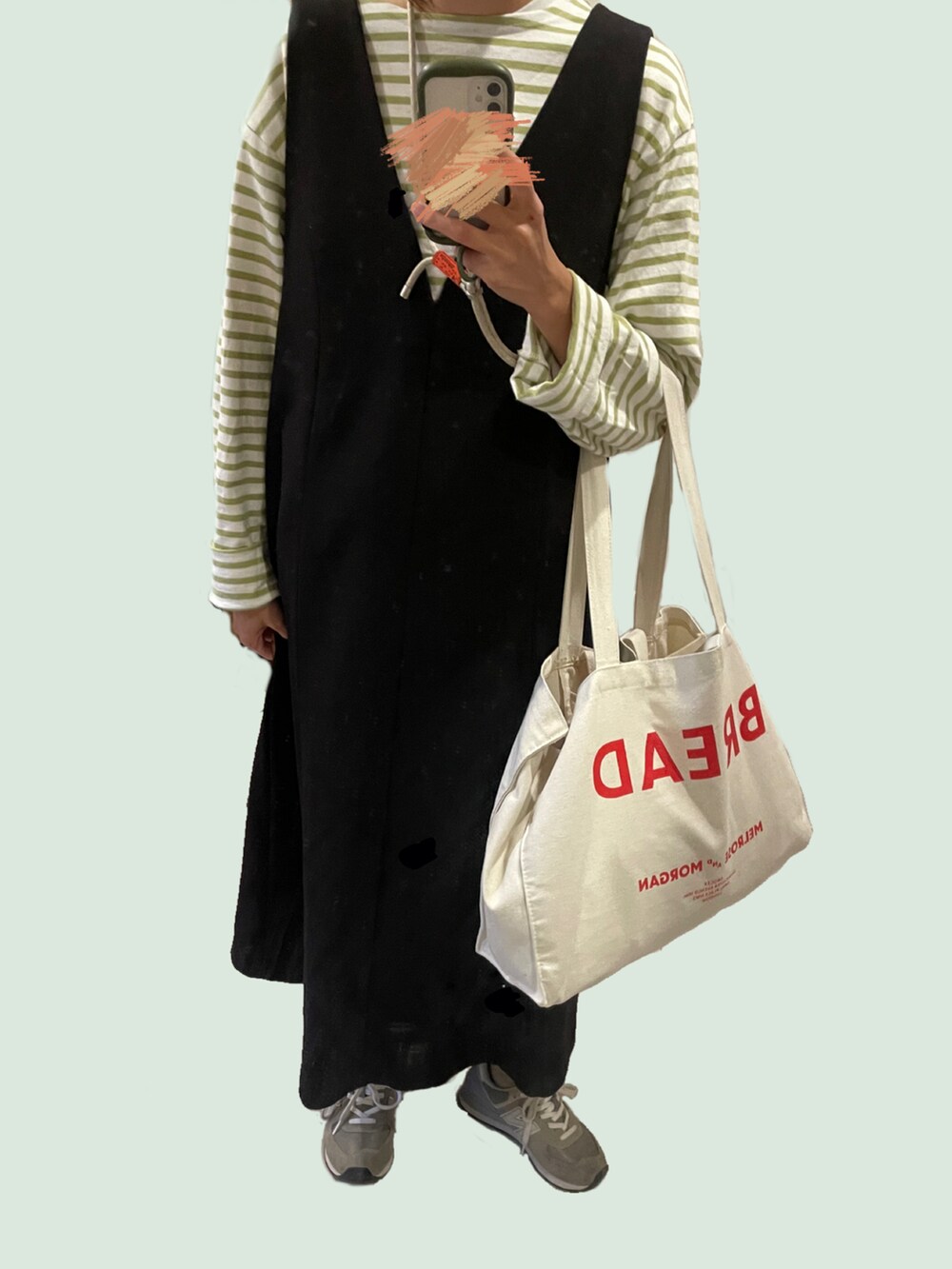 ブラック系のワンピース、グリーン系のTシャツ/カットソー、グレー系のスニーカーを着用したレディースの秋コーディネートの2枚目の写真