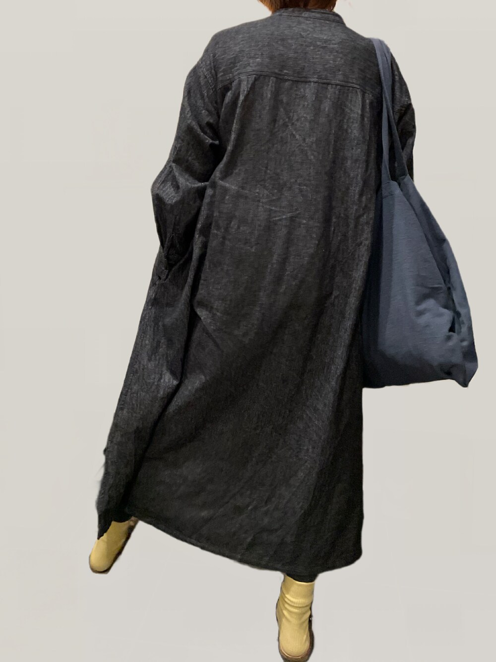 ブラウン系のスニーカー、グレー系のトートバッグ、ブラック系のワンピースを着用したレディースの秋コーディネートの2枚目の写真