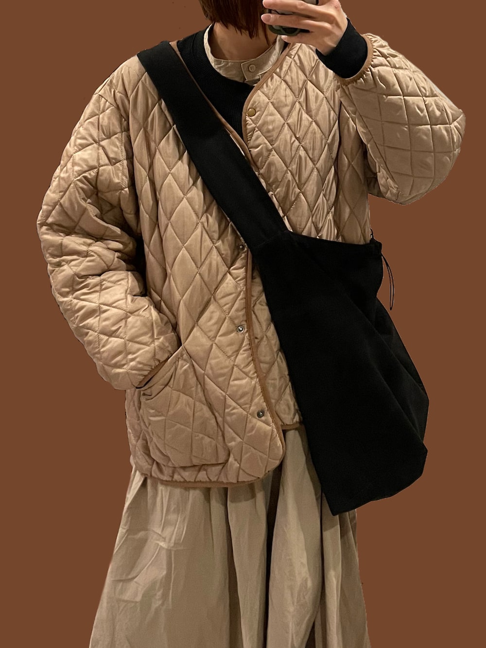 ブラック系のカーディガン/ボレロ、ブラック系のスニーカー、ベージュ系のブルゾンを着用したレディースの冬コーディネートの2枚目の写真