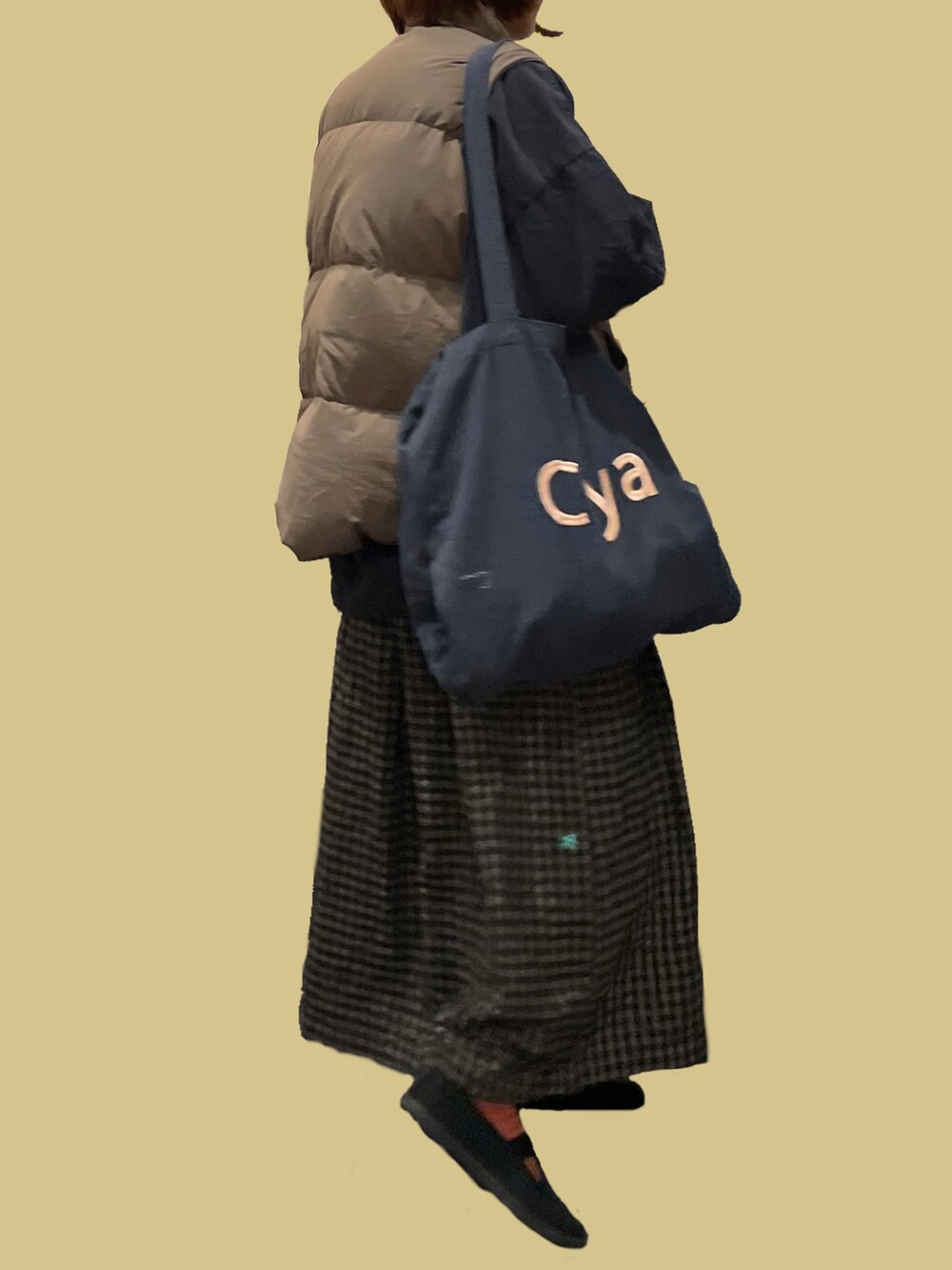 グレー系のトートバッグ、グレー系のシャツ/ブラウス、ベージュ系のダウンベストを着用したレディースの冬コーディネートの2枚目の写真