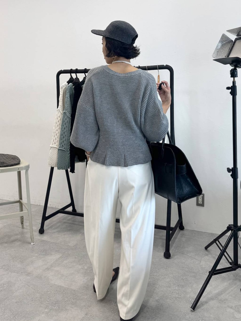 ホワイト系のスラックス、ブラック系のショルダーバッグ、グレー系のカーディガン/ボレロを着用したレディースの秋コーディネートの2枚目の写真