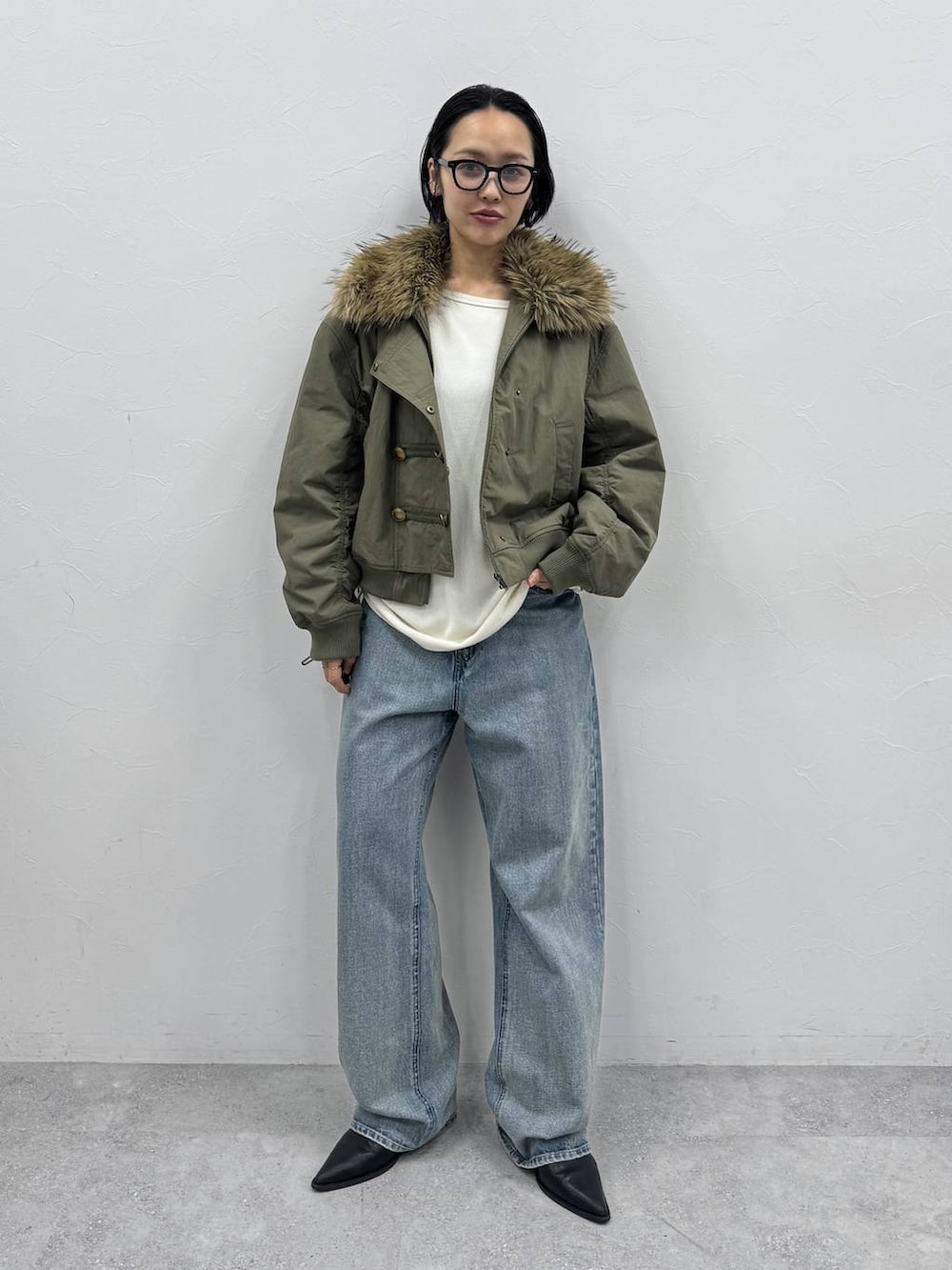 ブルー系のデニムパンツ、ブラック系のブーツ、ホワイト系のTシャツ/カットソーを着用したレディースの秋コーディネートの4枚目の写真