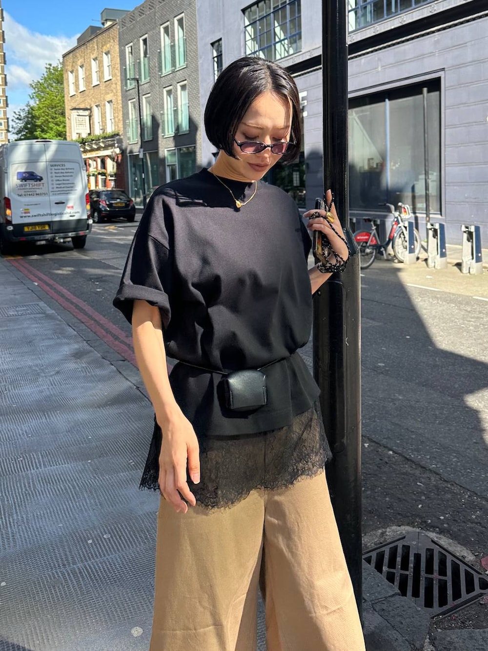 ブラック系のTシャツ/カットソー、ブラック系のベルト、ブラック系のサングラスを着用したレディースの夏コーディネートの3枚目の写真