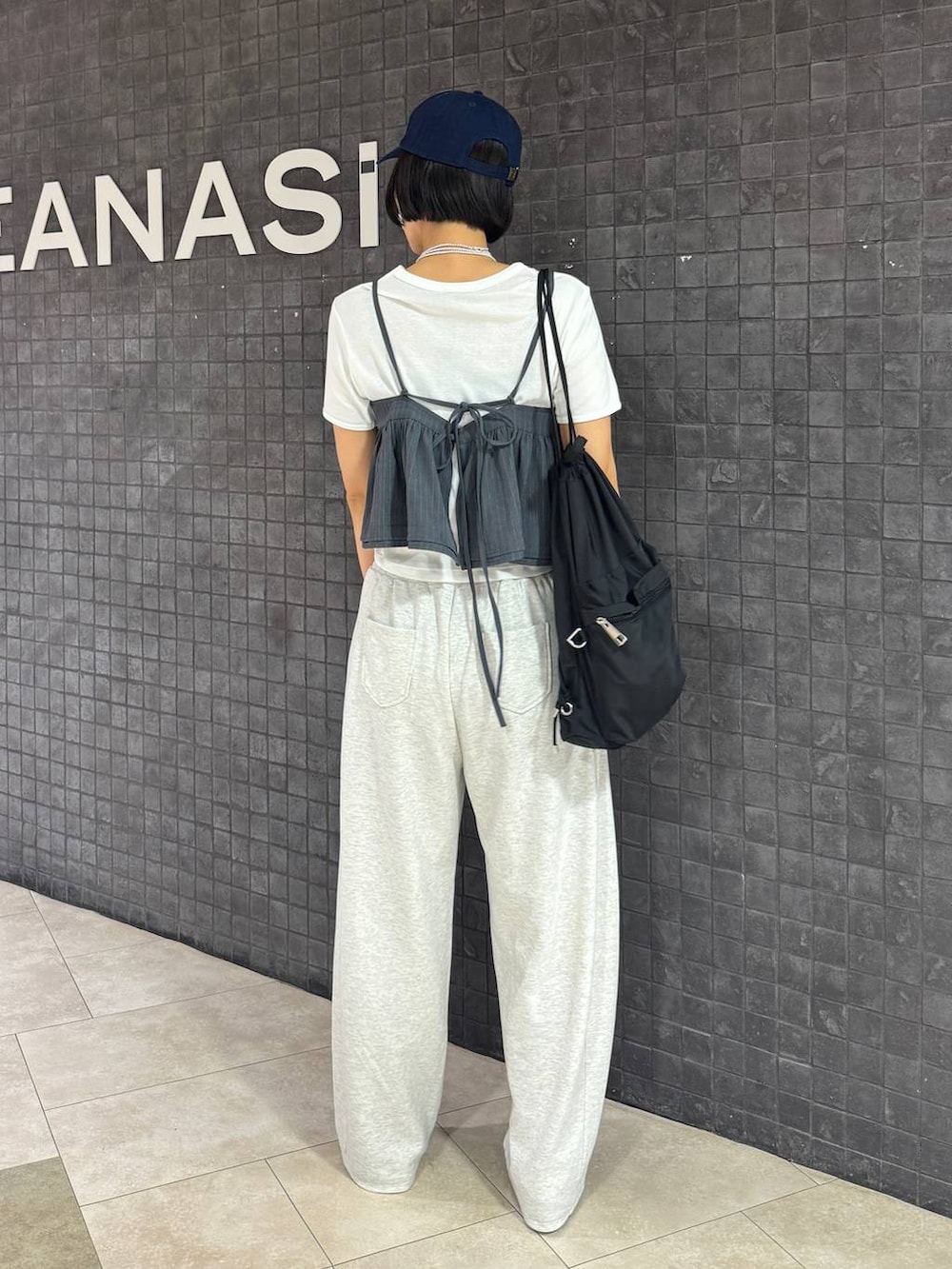 ブラック系のパンプス、ホワイト系のTシャツ/カットソー、ベージュ系のスウェットパンツを着用したレディースの夏コーディネートの3枚目の写真