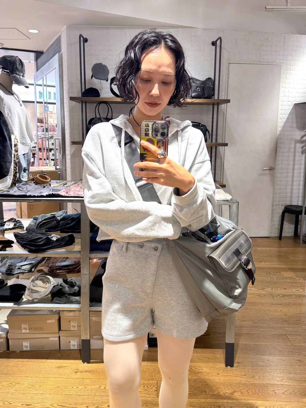 グリーン系のトートバッグ、グレー系のスウェットパンツ、グレー系のパーカーを着用したレディースの冬コーディネートの4枚目の写真