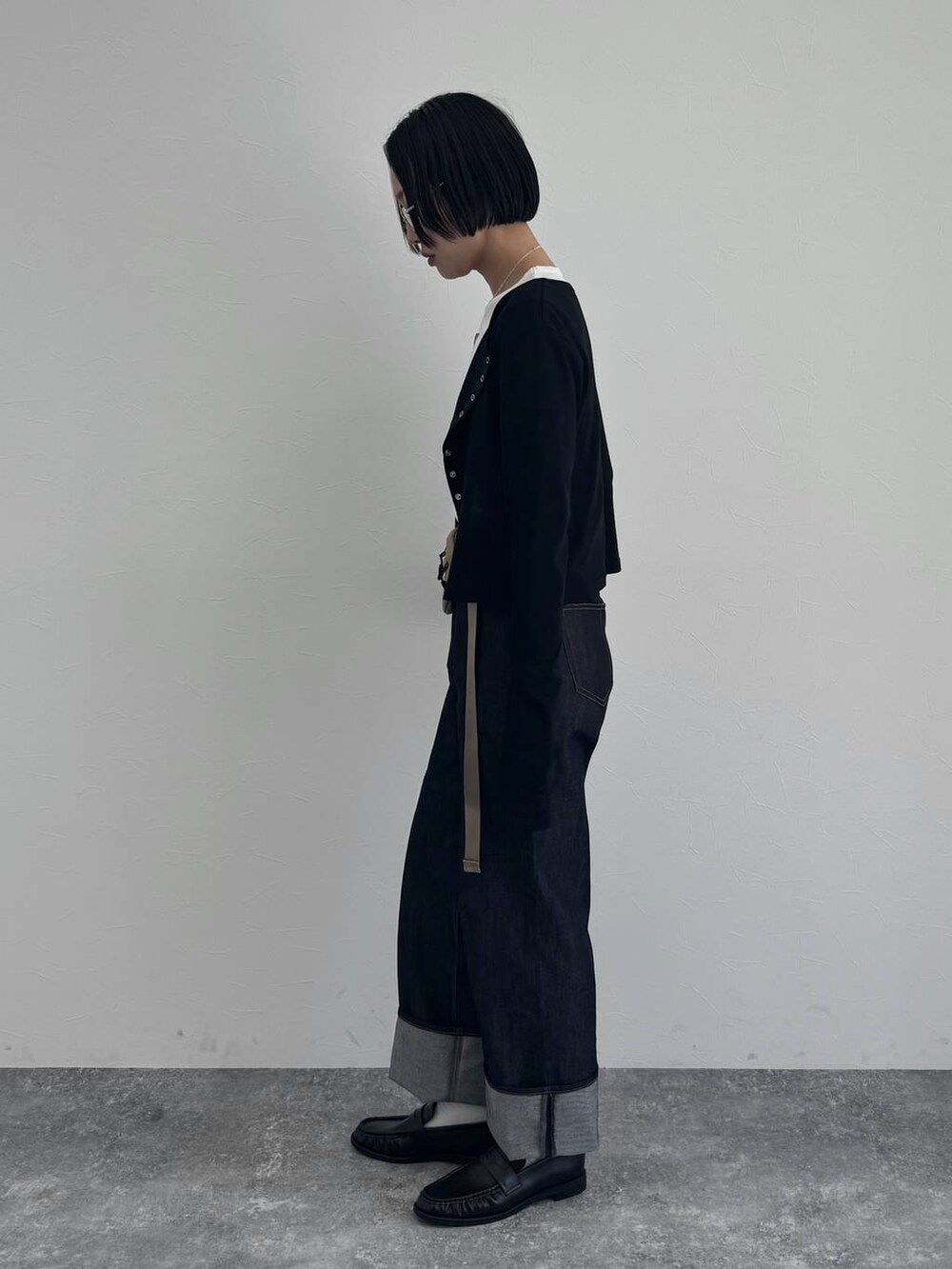 ブラック系のローファー、ブルー系のデニムパンツを着用したレディースの冬コーディネートの3枚目の写真