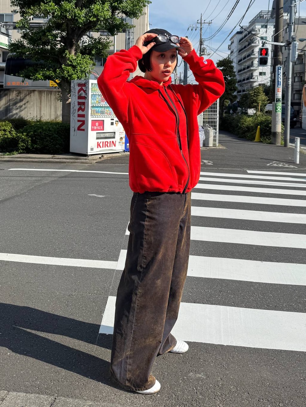 ブラウン系のデニムパンツ、レッド系のパーカーを着用したレディースの夏コーディネートの4枚目の写真