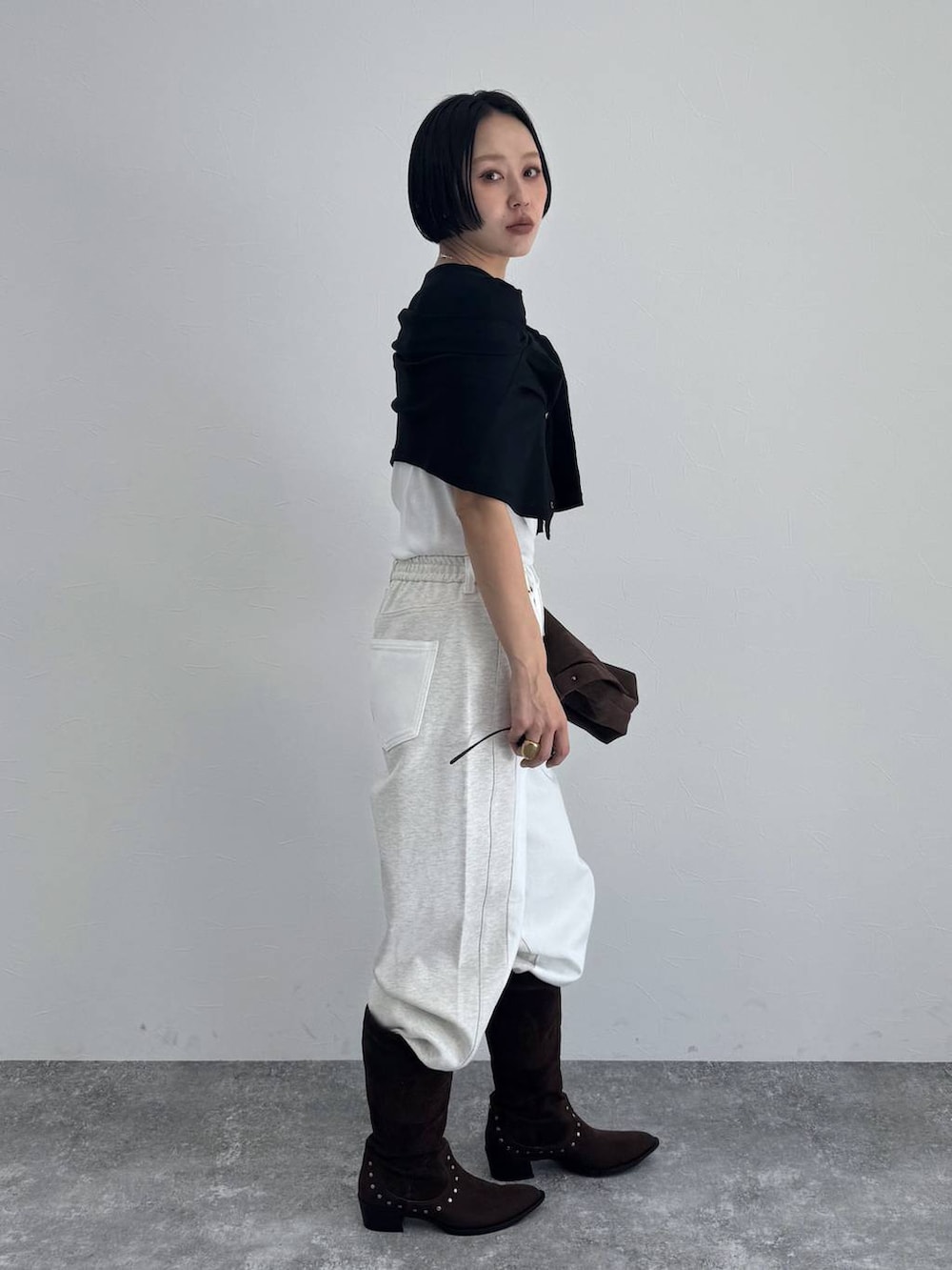 ブラック系のブーツ、ブラウン系のショルダーバッグを着用したレディースの冬コーディネートの3枚目の写真