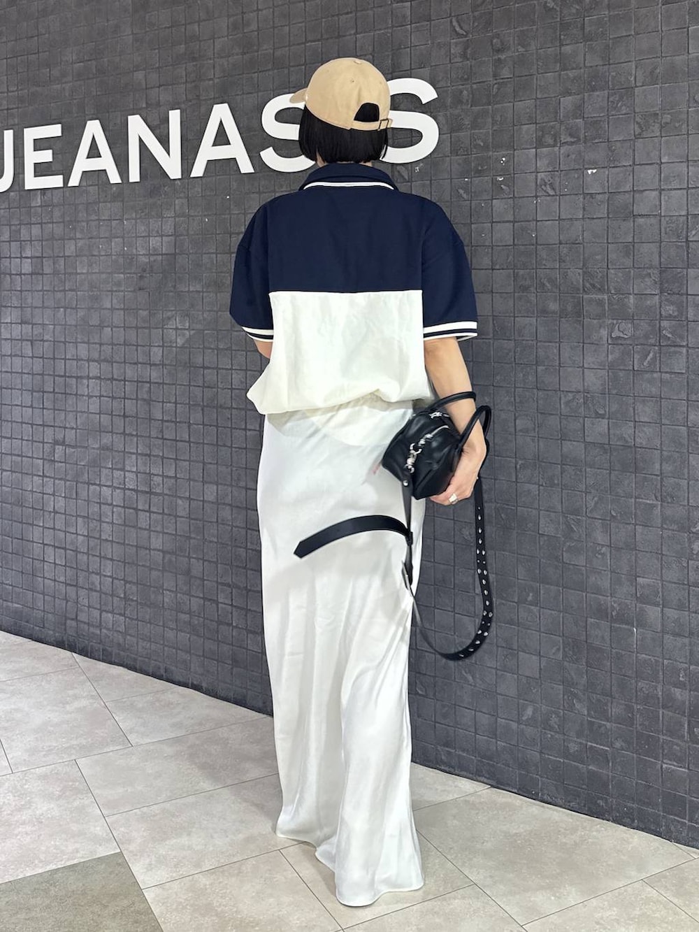 ブラック系のボストンバッグ、ブラック系のスカート、ブラック系のローファーを着用したレディースの春コーディネートの5枚目の写真