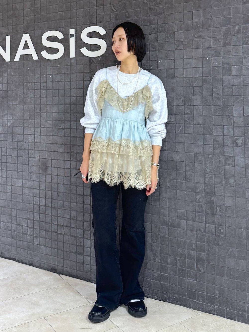 グレー系のスウェット、ブルー系のデニムパンツを着用したレディースの春コーディネートの2枚目の写真