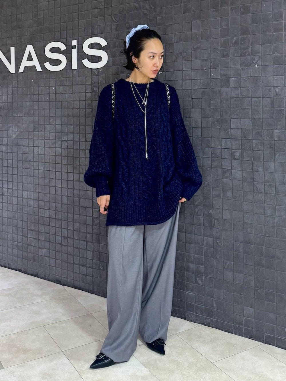 ブラック系のパンプス、グレー系のスラックスを着用したレディースの秋コーディネートの5枚目の写真