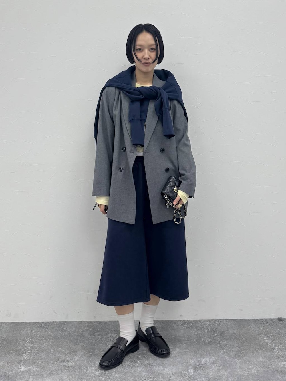 グレー系のテーラードジャケット、ブラック系のローファーを着用したレディースの冬コーディネートの5枚目の写真