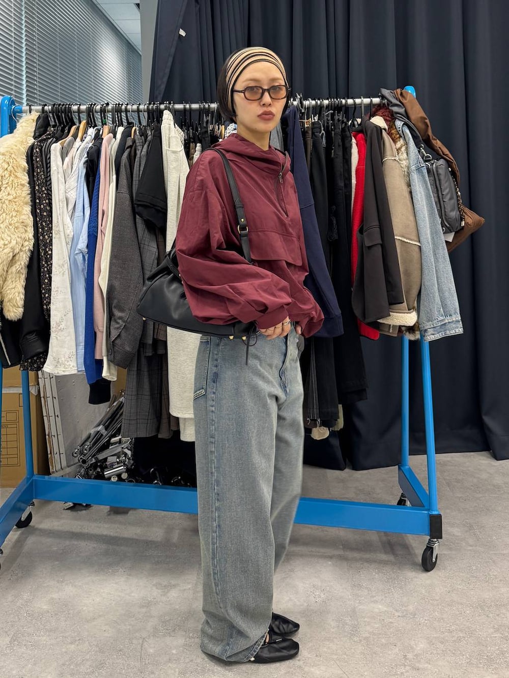 ブルー系のデニムパンツ、ブラック系のショルダーバッグを着用したレディースの夏コーディネートの4枚目の写真