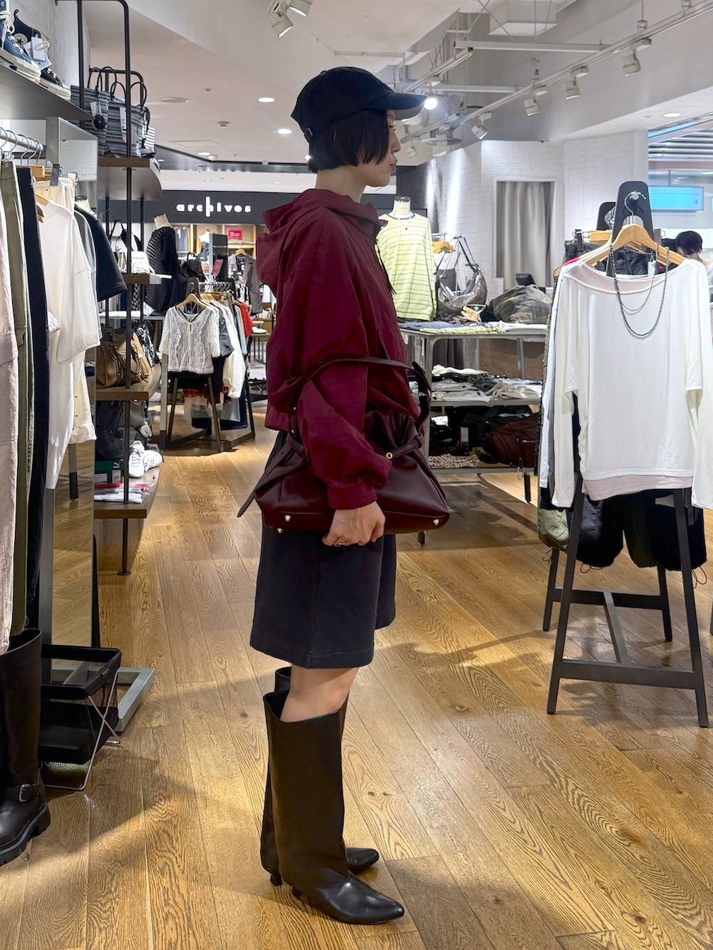 ブラック系のスウェットパンツ、ブラック系のブーツ、レッド系のショルダーバッグを着用したレディースの夏コーディネートの2枚目の写真