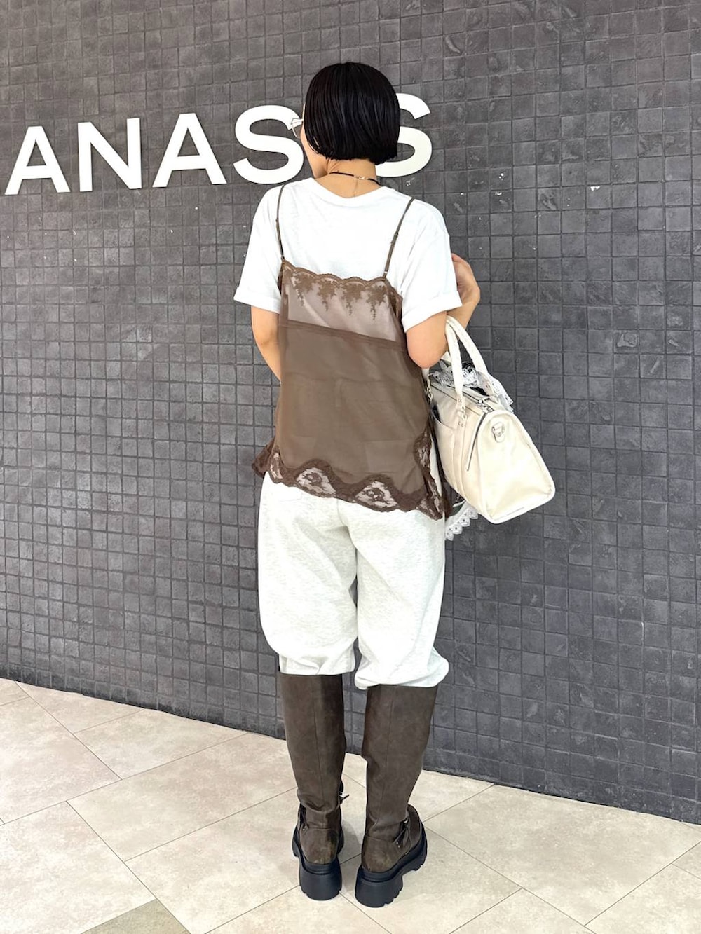 ホワイト系のTシャツ/カットソー、ホワイト系のデニムパンツ、ホワイト系のボストンバッグを着用したレディースの夏コーディネートの4枚目の写真
