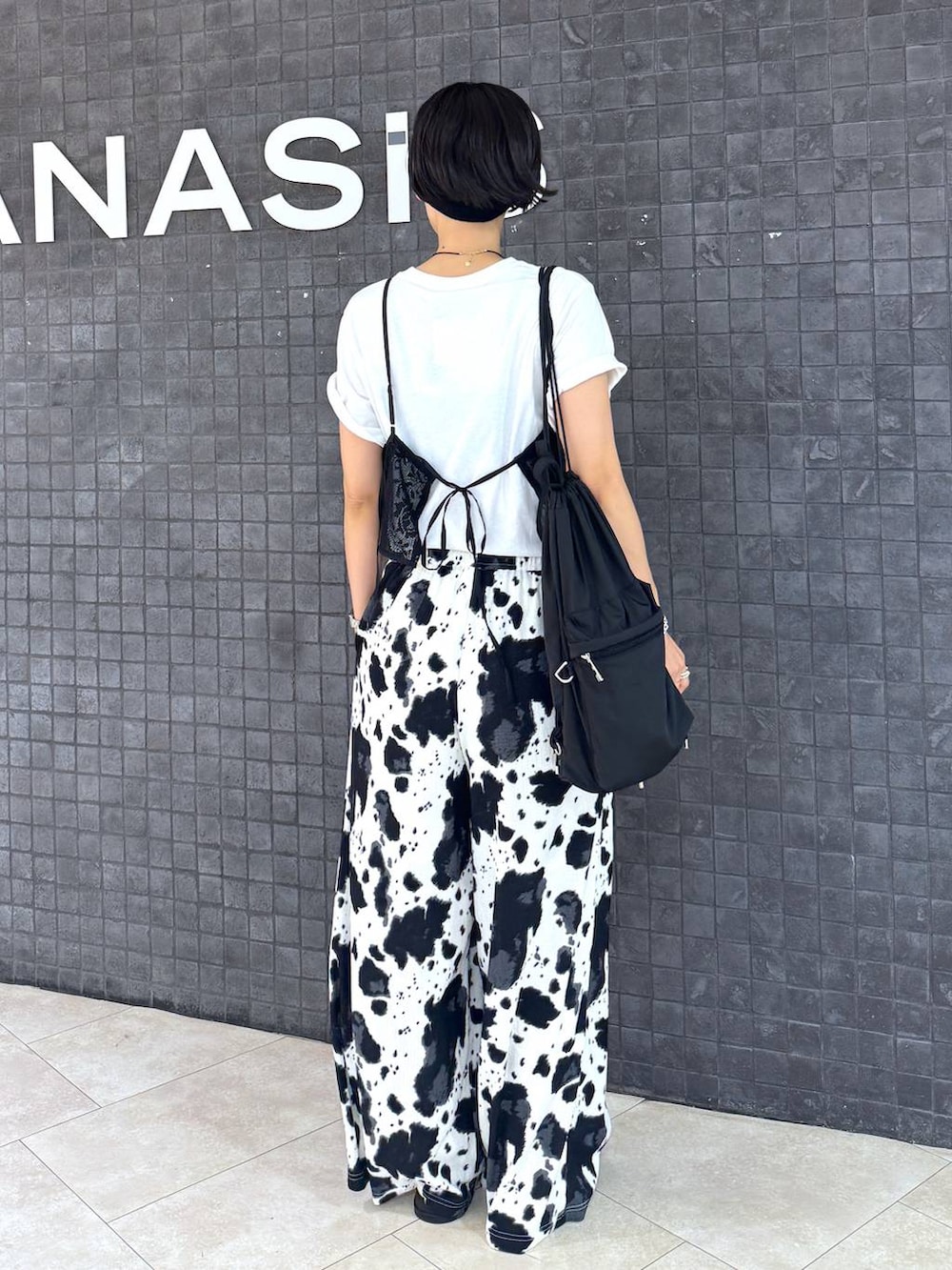 ブラック系のその他パンツ、ホワイト系のサンダル、ホワイト系のTシャツ/カットソーを着用したレディースの夏コーディネートの2枚目の写真