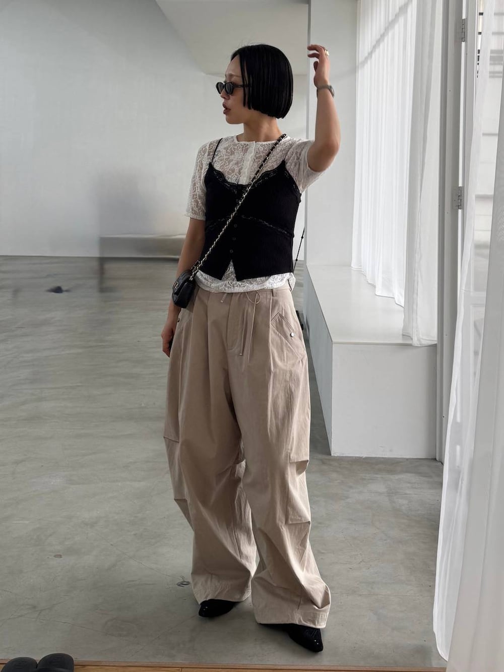 ブラック系のパンプス、ベージュ系のその他パンツ、ホワイト系のTシャツ/カットソーを着用したレディースの春コーディネートの2枚目の写真