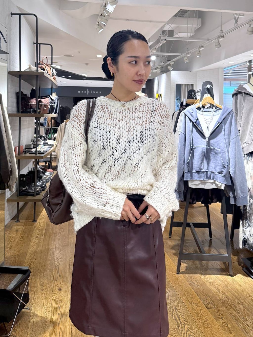 ブラウン系のショルダーバッグ、ホワイト系のニット/セーター、ブラウン系のスカートを着用したレディースの秋コーディネートの5枚目の写真