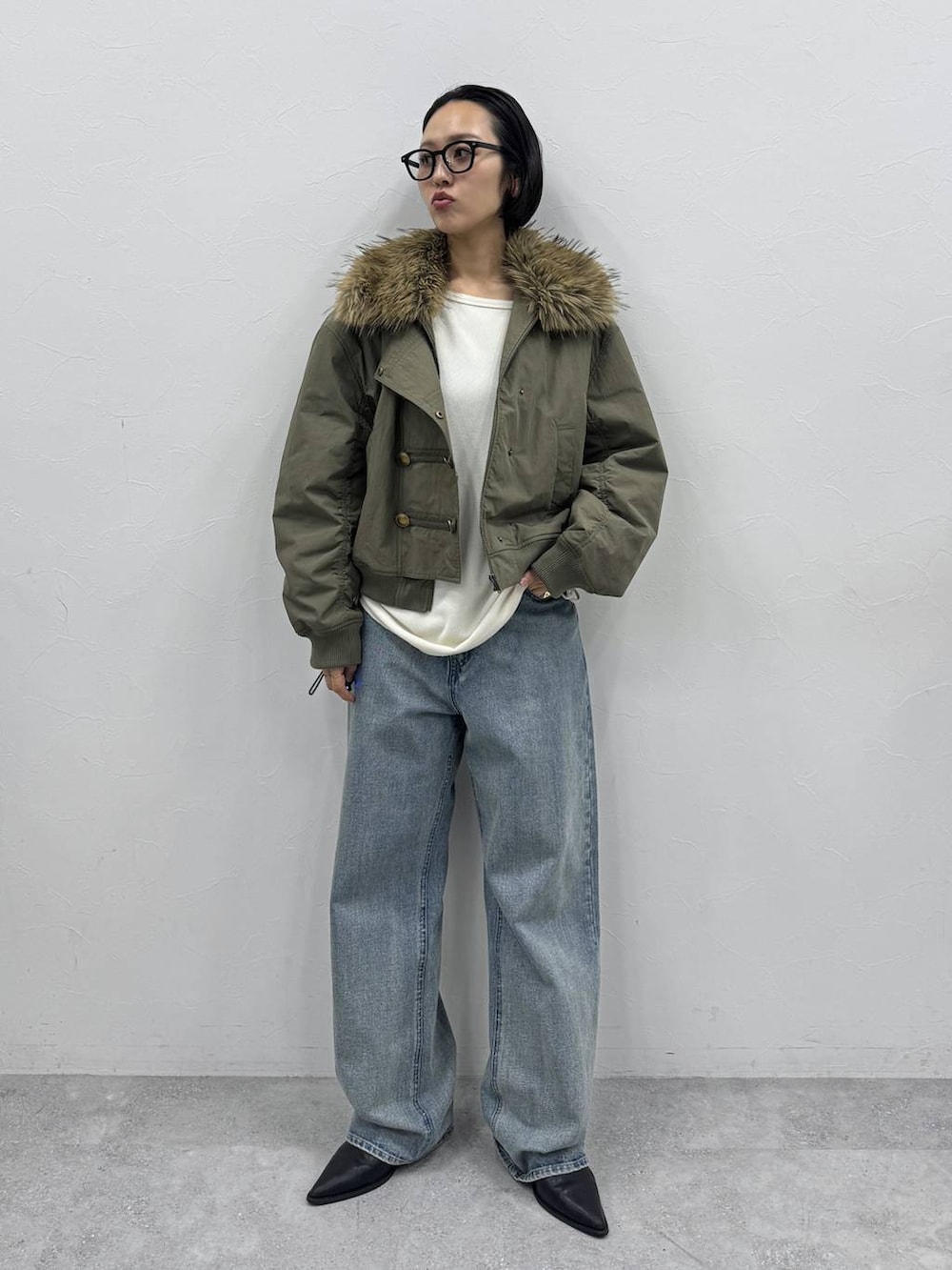 ブルー系のデニムパンツ、ブラック系のブーツ、ホワイト系のTシャツ/カットソーを着用したレディースの秋コーディネートの3枚目の写真