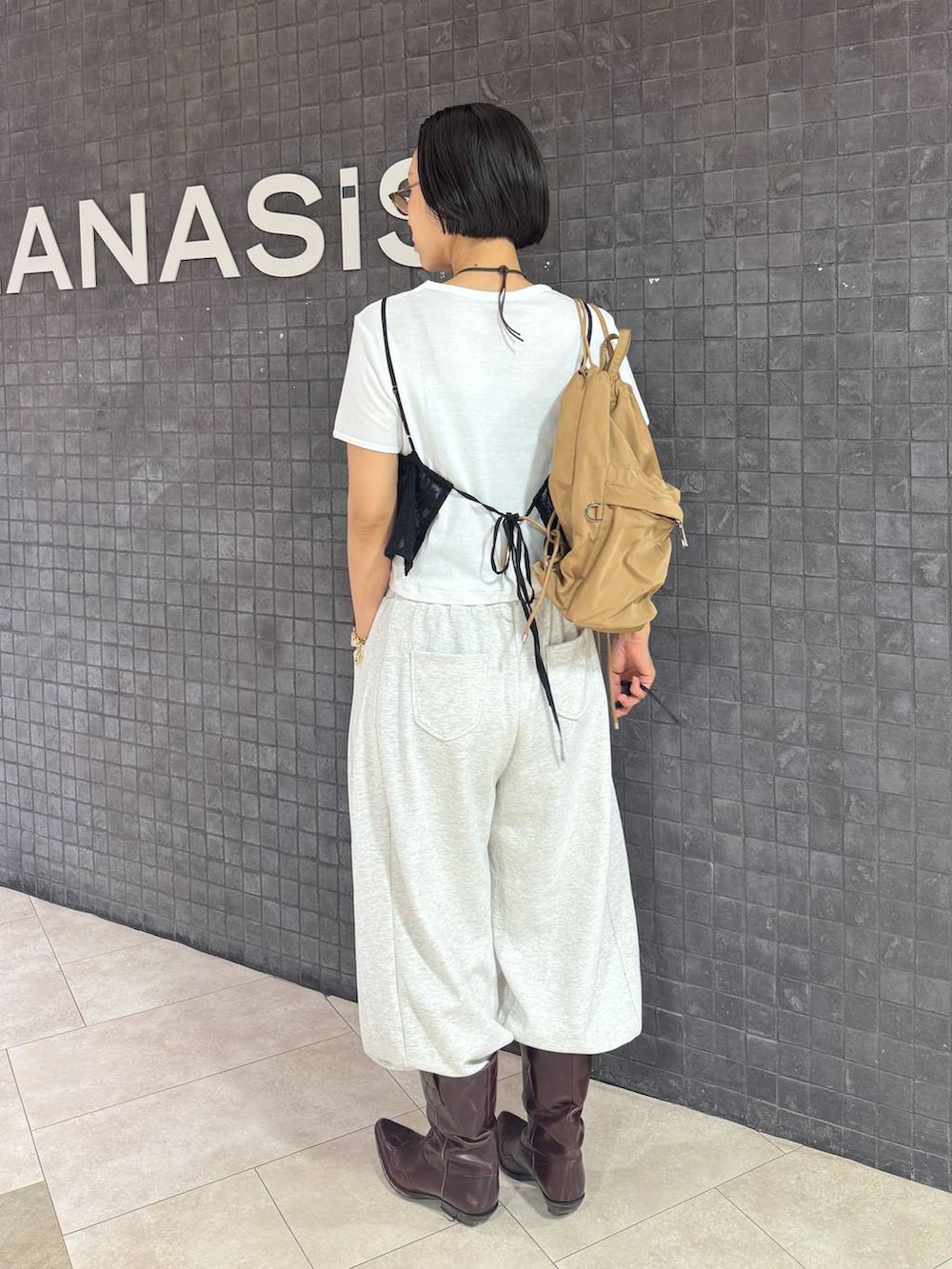 ホワイト系のTシャツ/カットソー、ベージュ系のスウェットパンツ、ブラウン系のサングラスを着用したレディースの夏コーディネートの3枚目の写真