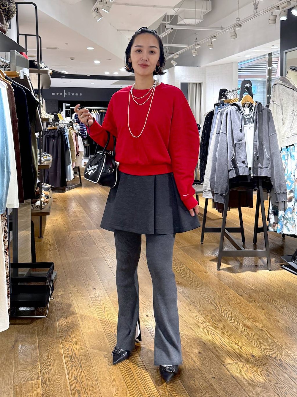 ブラック系のパンプス、ホワイト系のショルダーバッグ、グレー系のその他パンツを着用したレディースの秋コーディネートの4枚目の写真