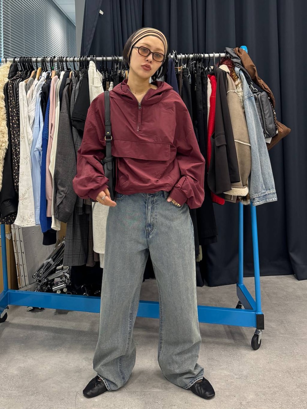 ブルー系のデニムパンツ、ブラック系のショルダーバッグを着用したレディースの夏コーディネートの5枚目の写真