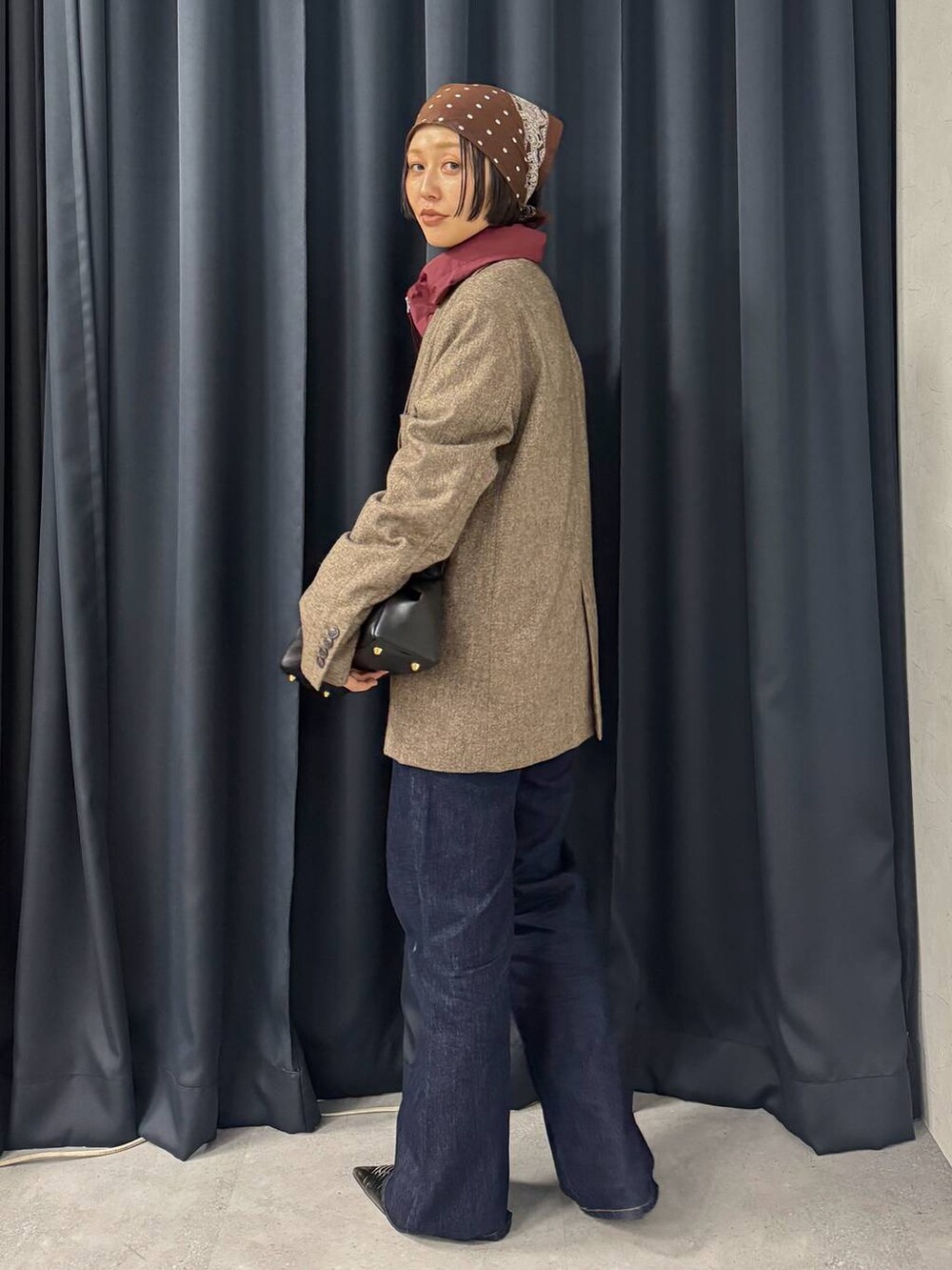 ブラック系のショルダーバッグ、ブルー系のデニムパンツ、ブラック系のパンプスを着用したレディースの夏コーディネートの4枚目の写真