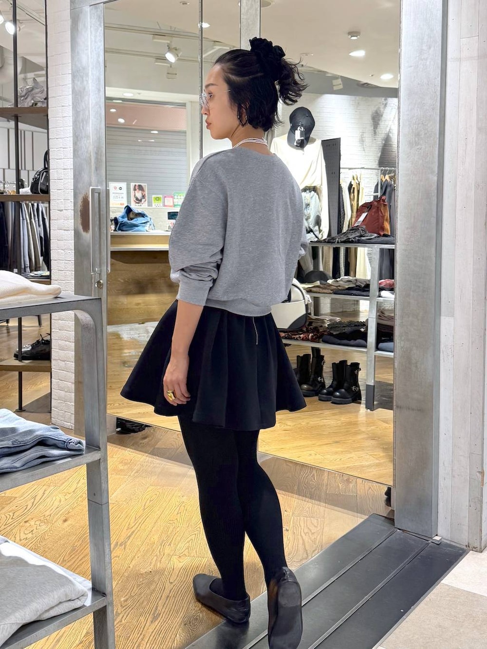 ホワイト系のショルダーバッグ、ブラック系のスカート、グレー系のスウェットを着用したレディースの秋コーディネートの4枚目の写真