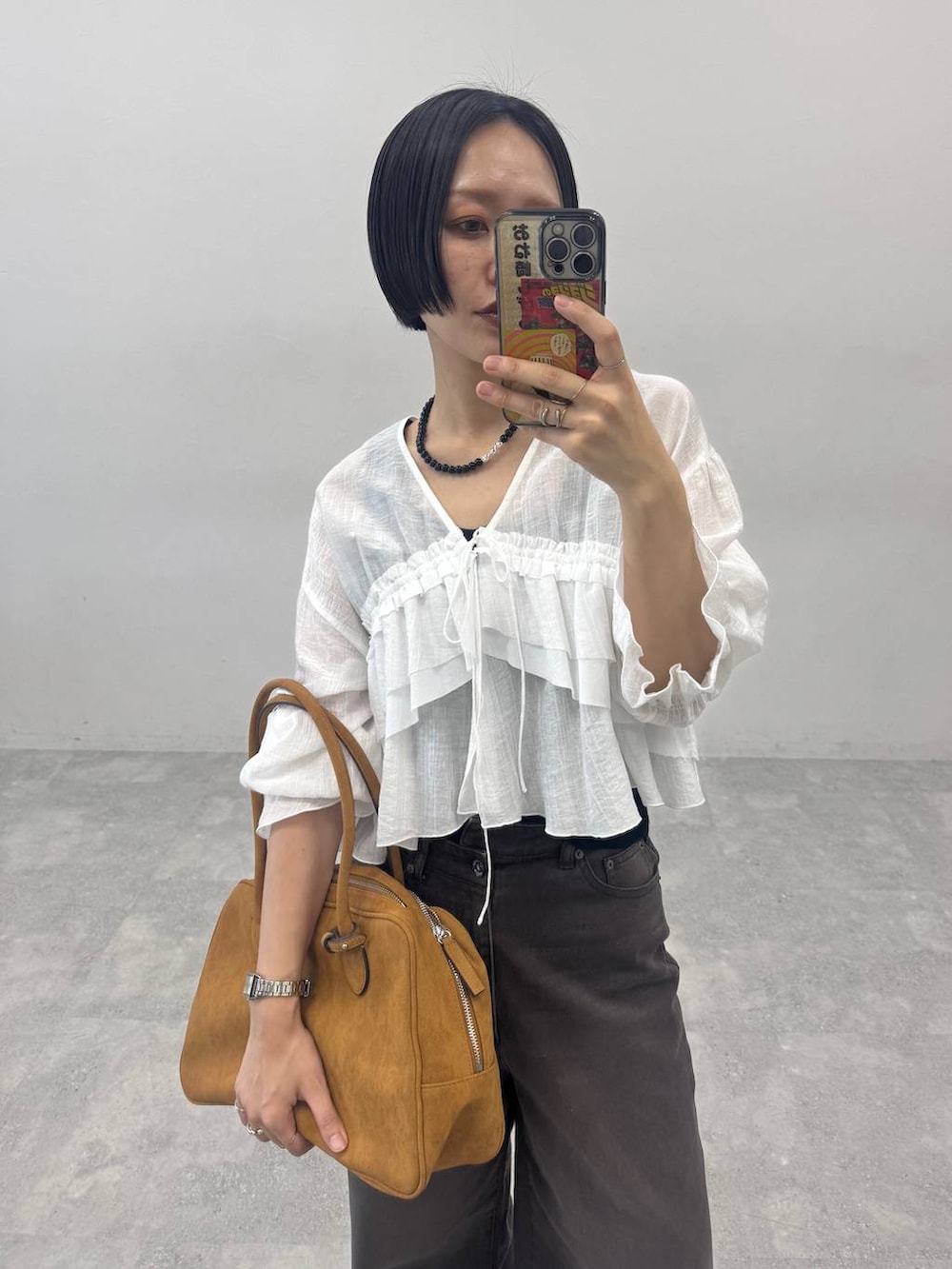 ブラウン系のボストンバッグ、ベージュ系のモカシン/デッキシューズ、ブラウン系のデニムパンツを着用したレディースの春コーディネートの3枚目の写真