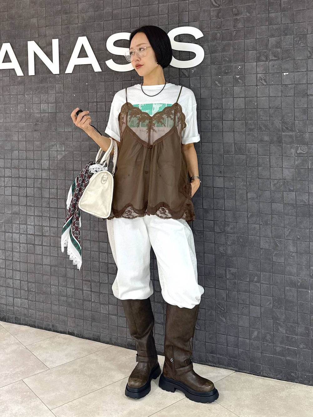 ホワイト系のTシャツ/カットソー、ホワイト系のデニムパンツ、ホワイト系のボストンバッグを着用したレディースの夏コーディネートの2枚目の写真