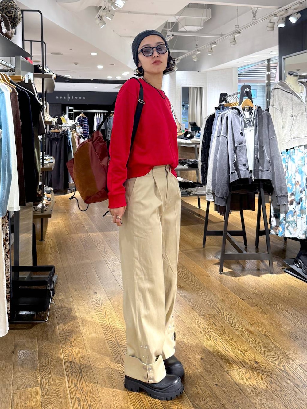 ブラウン系のショルダーバッグ、ブラック系のブーツ、ベージュ系のチノパンツを着用したレディースの秋コーディネートの4枚目の写真