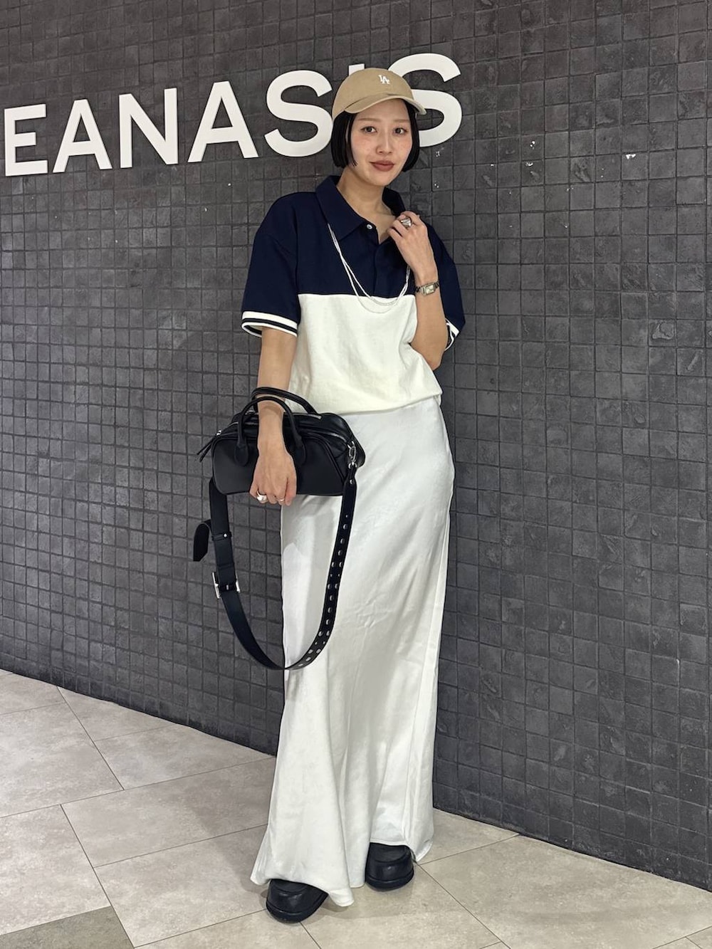 ブラック系のボストンバッグ、ブラック系のスカート、ブラック系のローファーを着用したレディースの春コーディネートの8枚目の写真