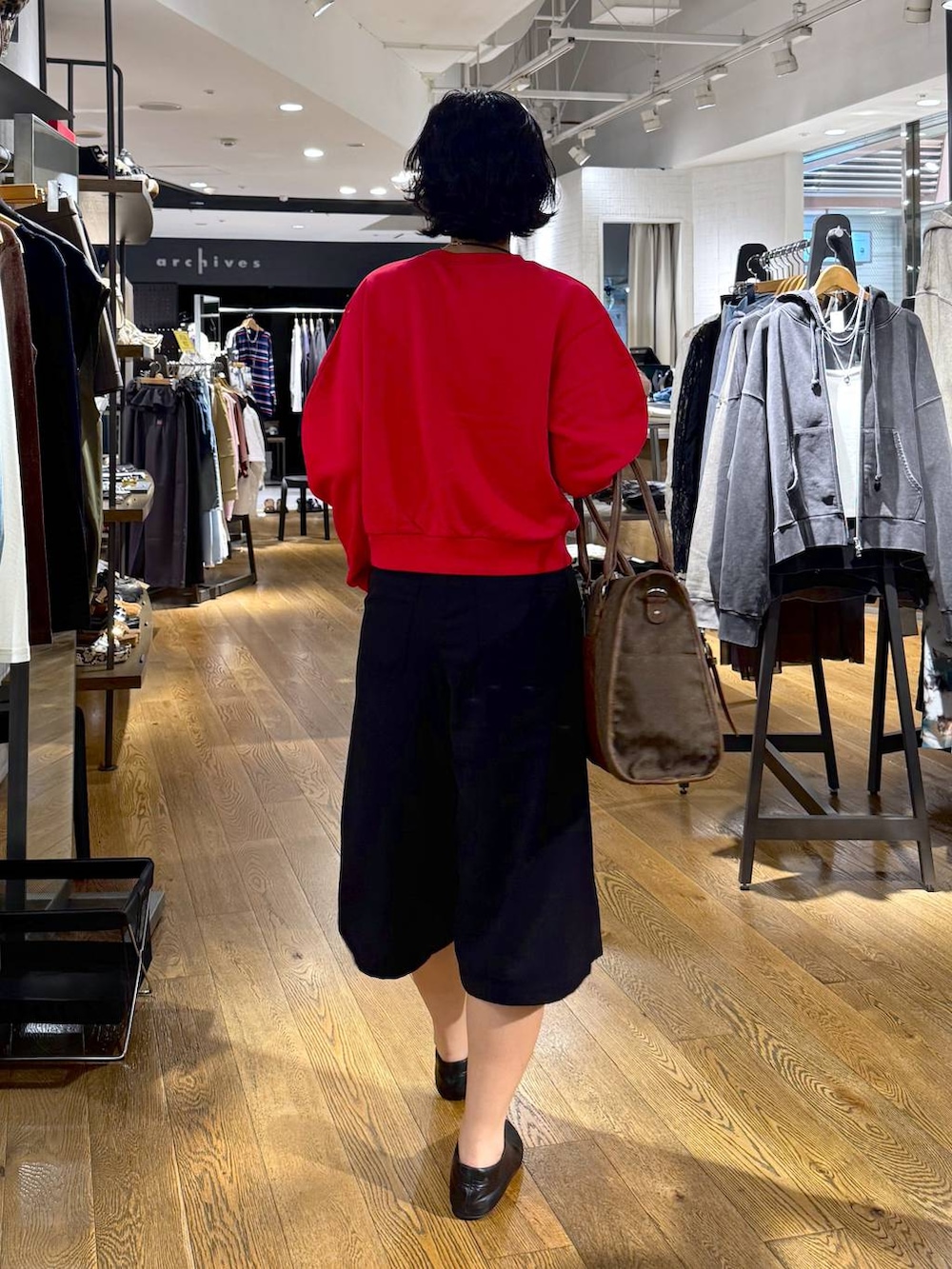 グリーン系のトートバッグ、ブラック系のその他パンツ、レッド系のスウェットを着用したレディースの秋コーディネートの3枚目の写真