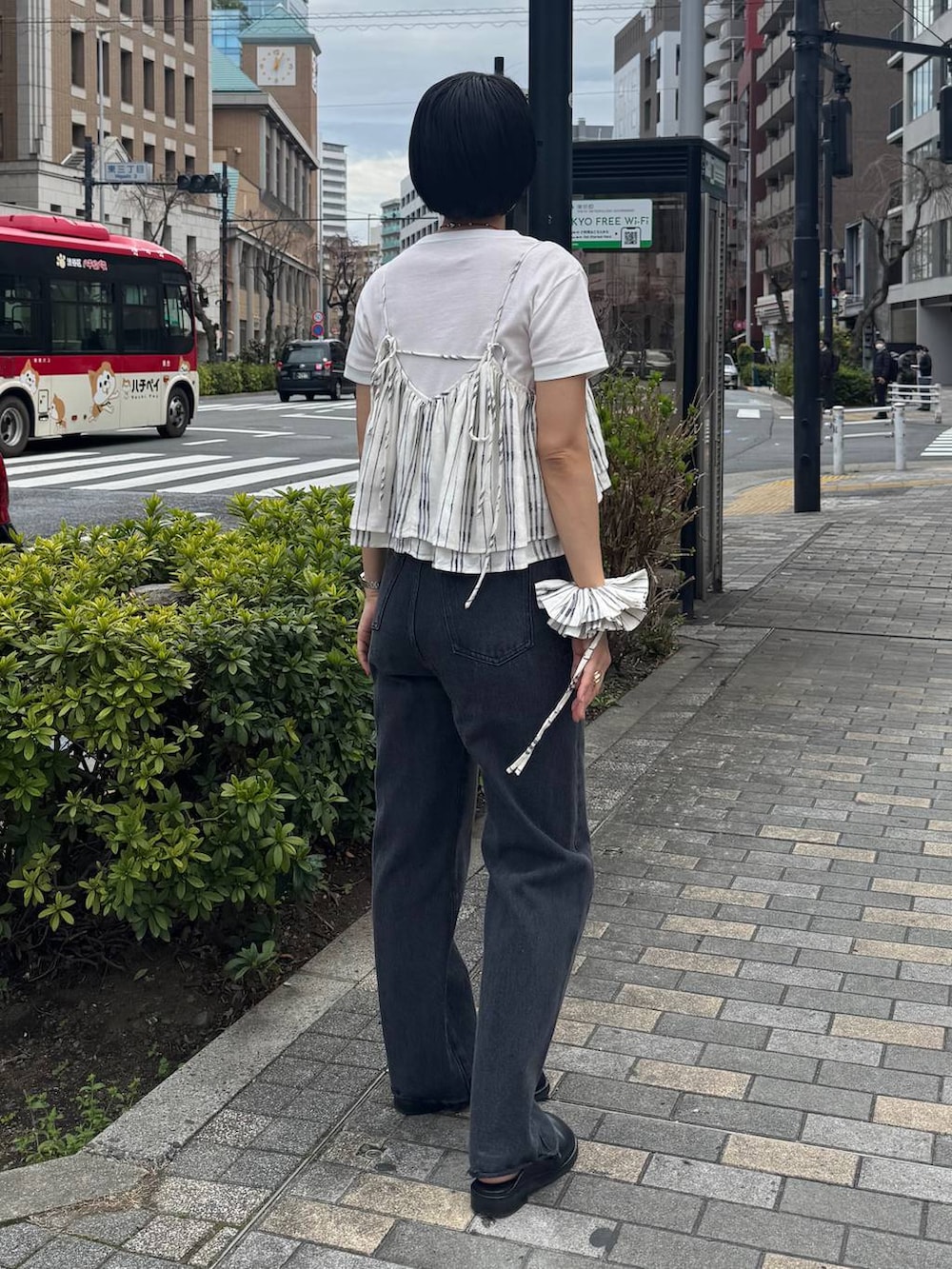 ブラック系のサンダル、ブラック系のデニムパンツを着用したレディースの春コーディネートの3枚目の写真