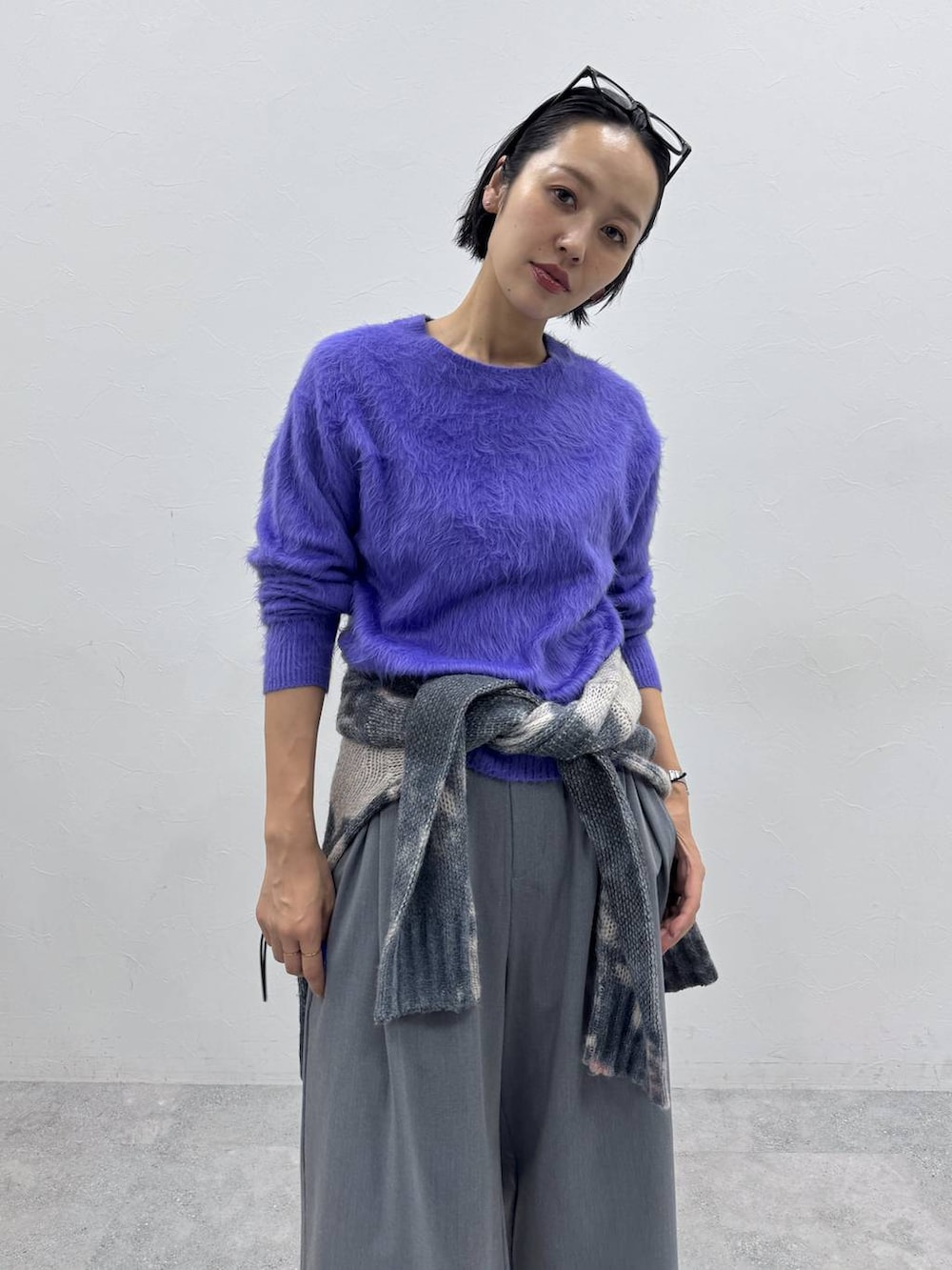 パープル系のニット/セーター、グレー系のスラックス、グレー系のニット/セーターを着用したレディースの秋コーディネートの2枚目の写真