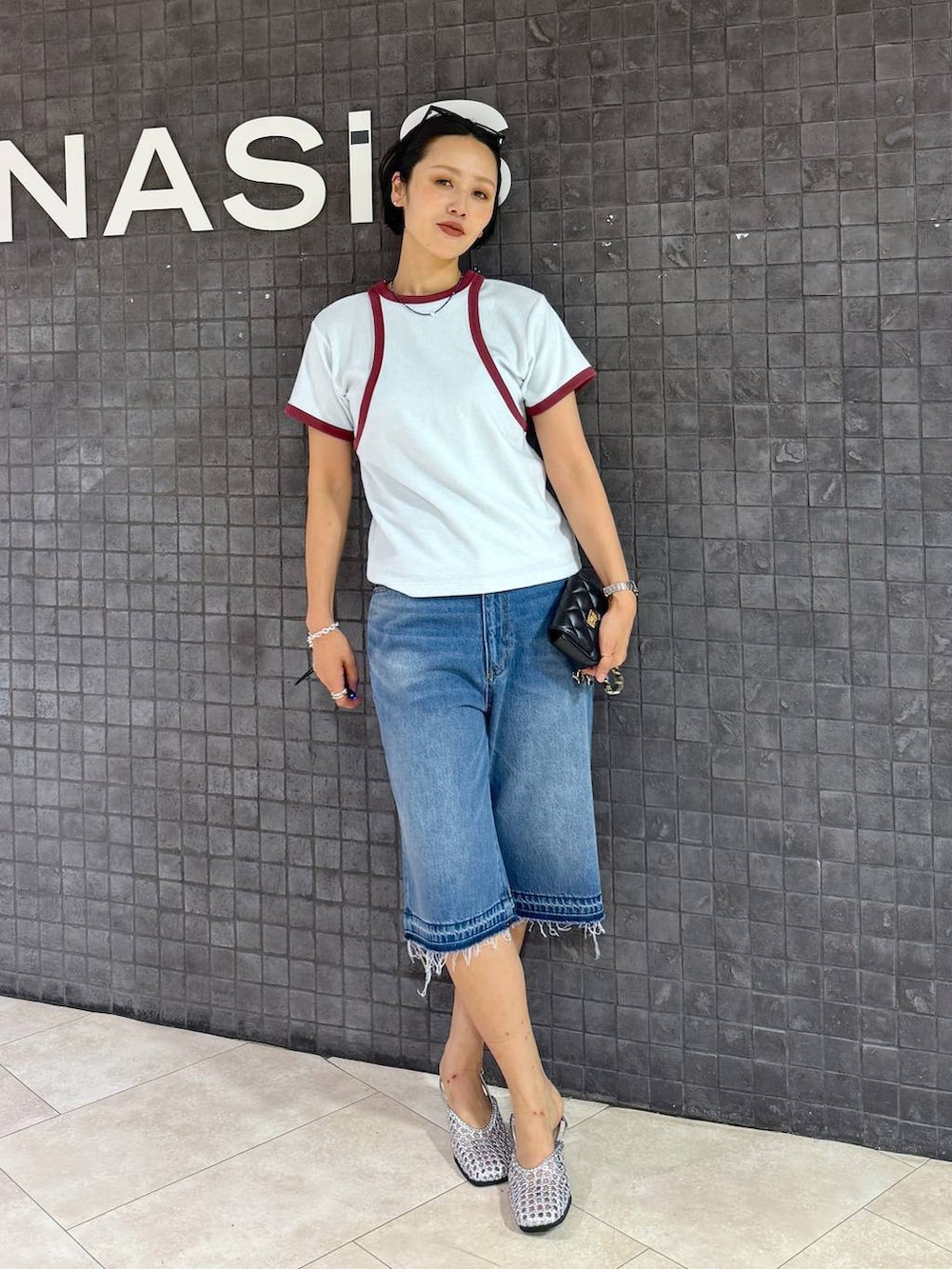 ブルー系のデニムパンツ、シルバー系のパンプスを着用したレディースの夏コーディネートの2枚目の写真
