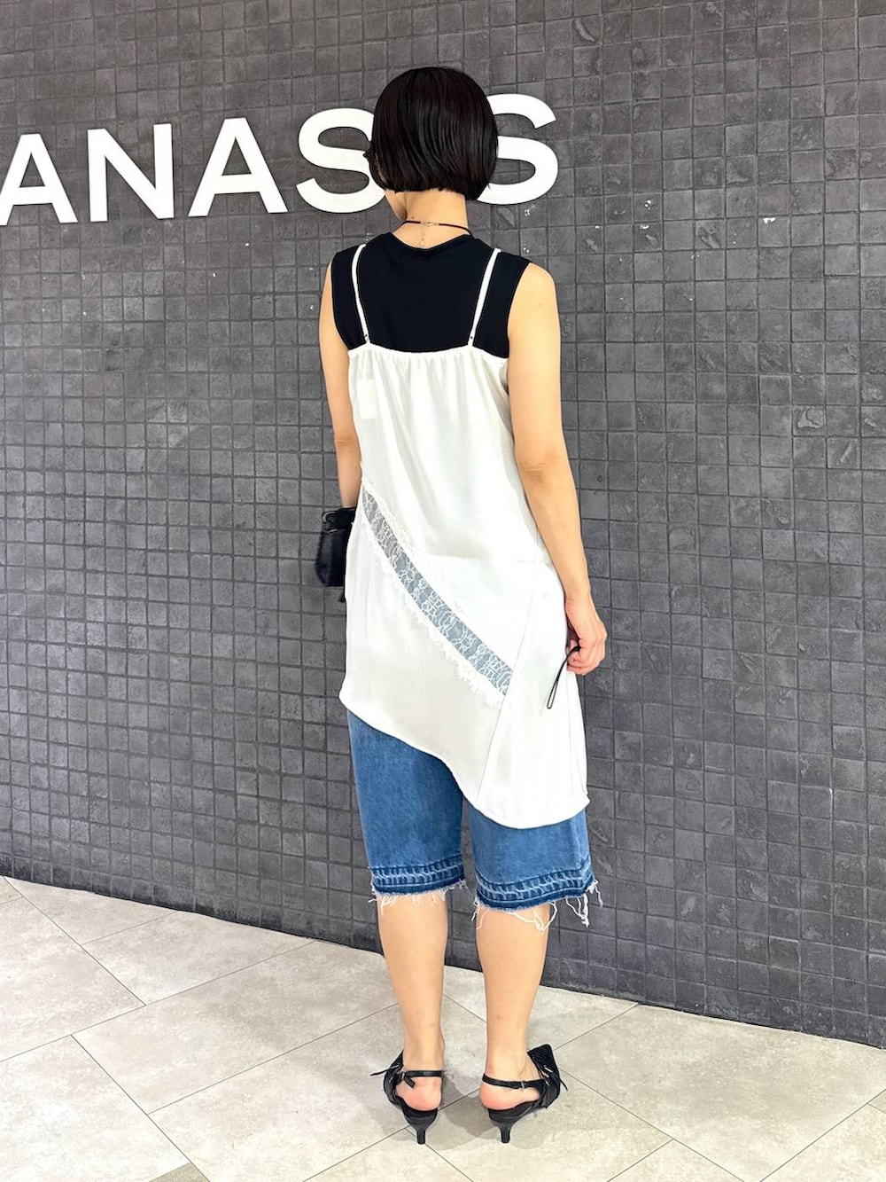 ブラック系のパンプス、ブルー系のデニムパンツ、ブラック系のTシャツ/カットソーを着用したレディースの夏コーディネートの3枚目の写真