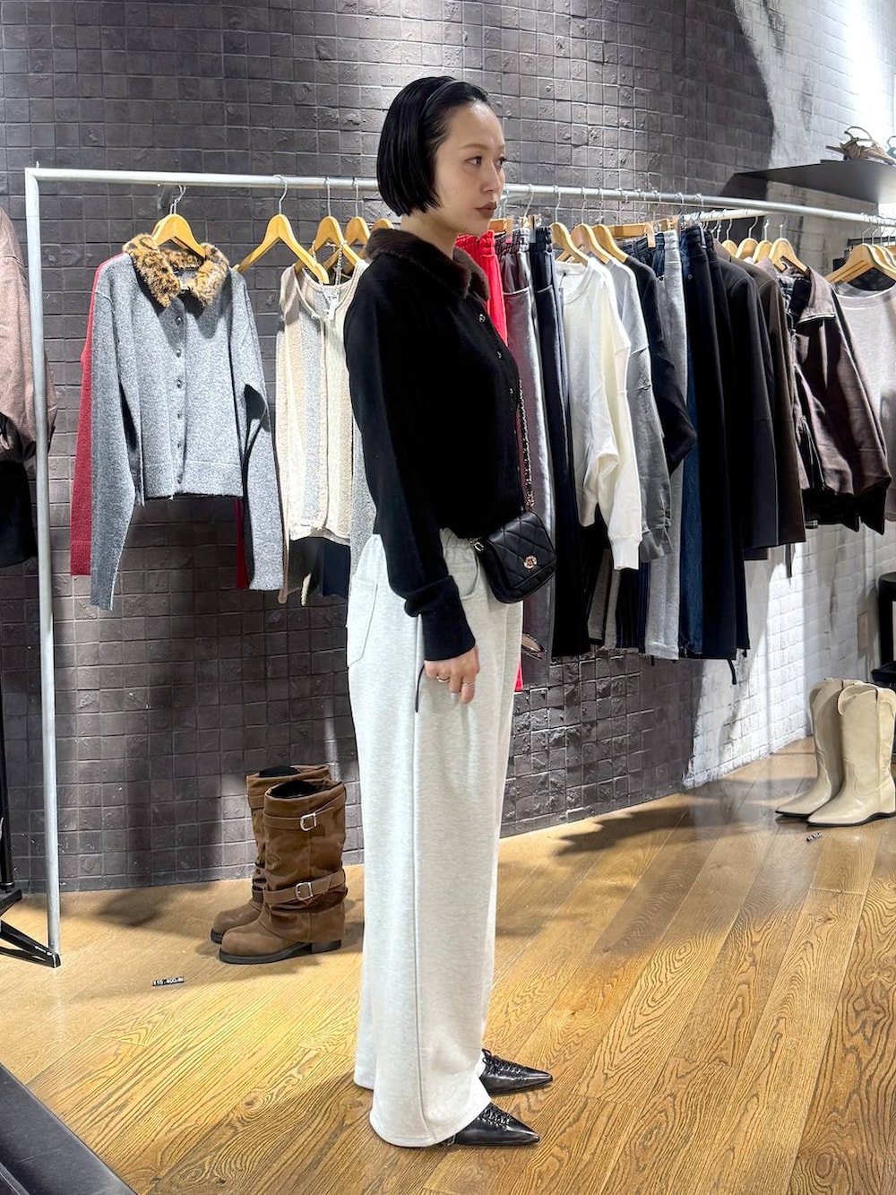 ブラック系のパンプス、ブラック系のカーディガン/ボレロ、ベージュ系のスウェットパンツを着用したレディースの秋コーディネートの2枚目の写真