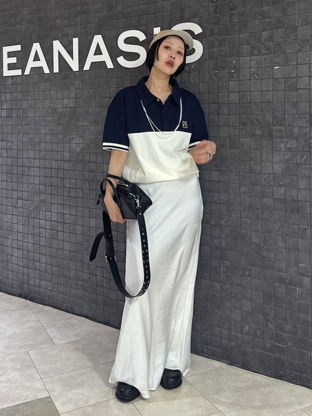 ブラック系のボストンバッグ、ブラック系のスカート、ブラック系のローファーを着用したレディースの春コーディネートの9枚目の写真