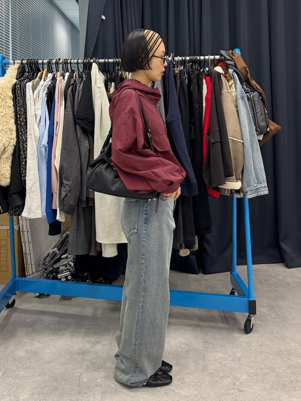 ブルー系のデニムパンツ、ブラック系のショルダーバッグを着用したレディースの夏コーディネートの3枚目の写真