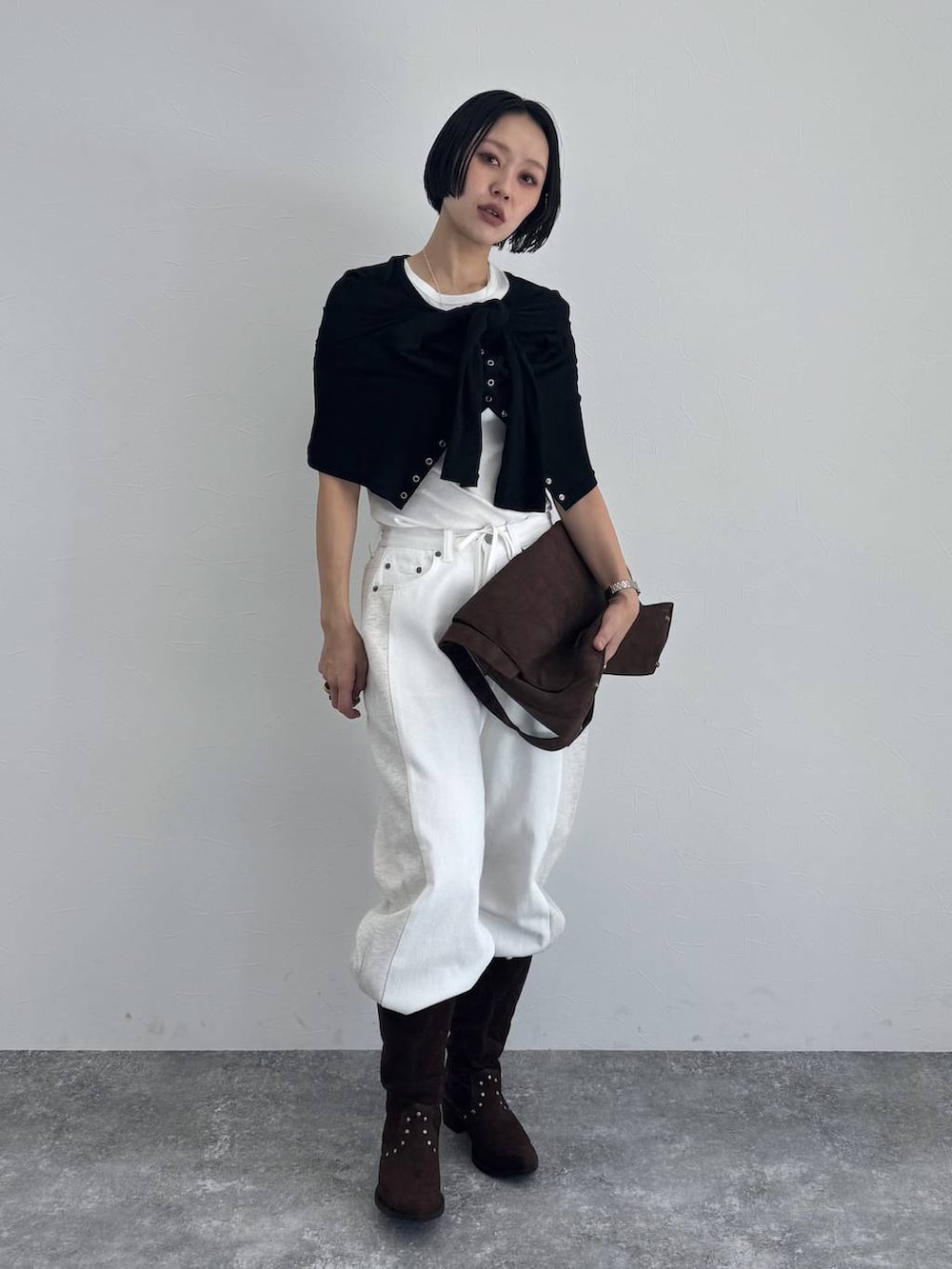 ブラック系のブーツ、ブラウン系のショルダーバッグを着用したレディースの冬コーディネートの2枚目の写真