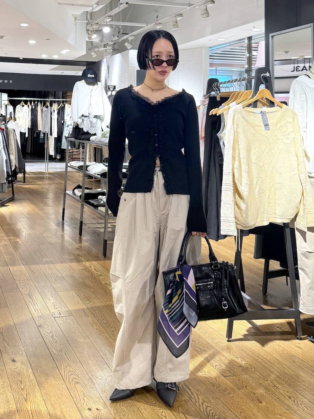 ブラック系のパンプス、ブラック系のボストンバッグ、ベージュ系のその他パンツを着用したレディースの春コーディネートの5枚目の写真