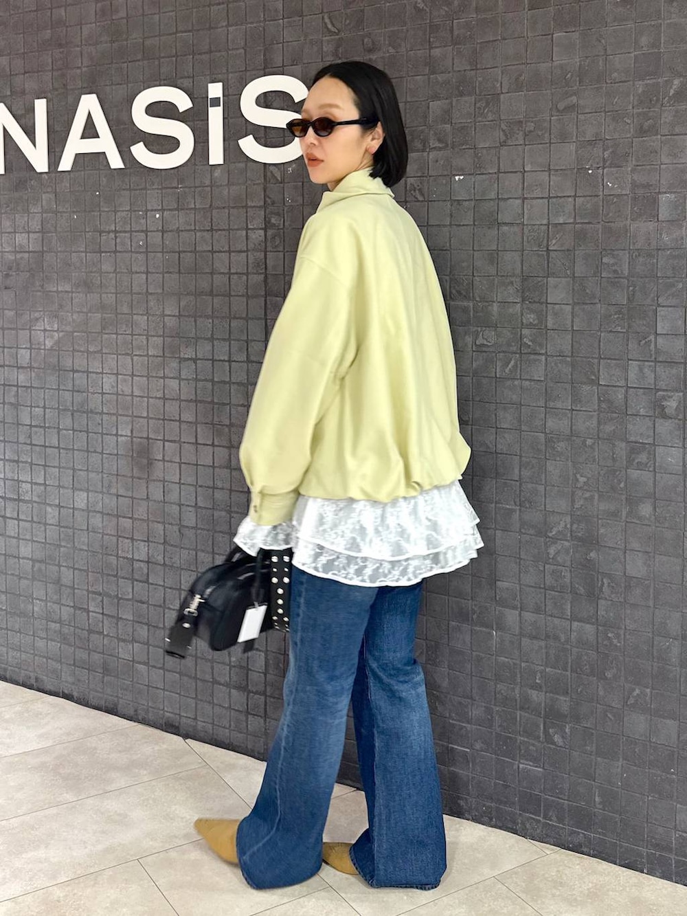 ホワイト系のシャツ/ブラウス、ブルー系のデニムパンツ、ベージュ系のパンプスを着用したレディースの春コーディネートの6枚目の写真