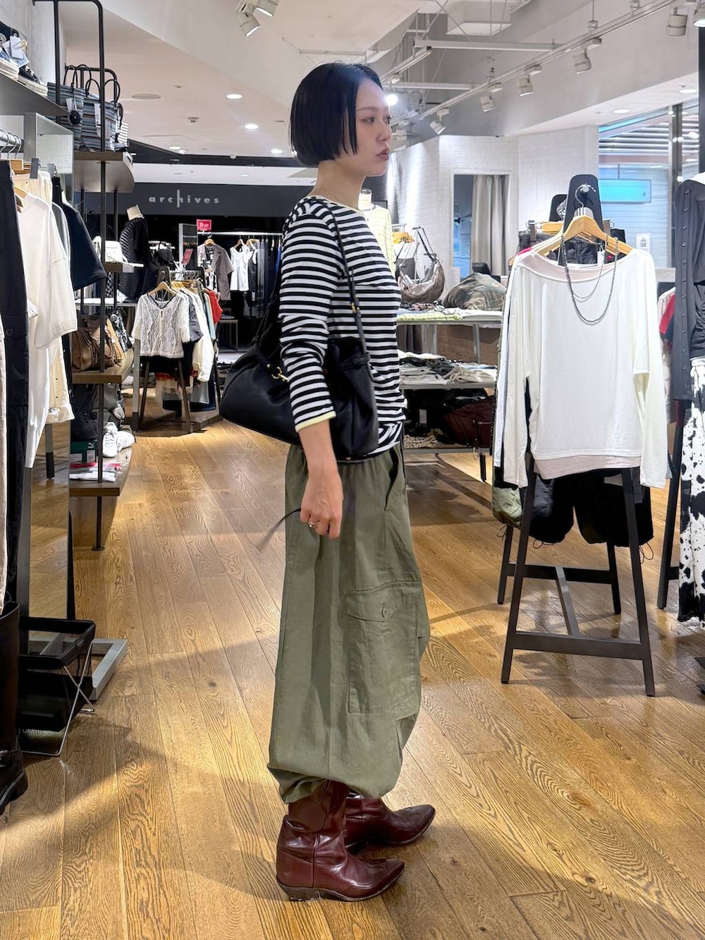 グリーン系のカーゴパンツ、ブラック系のショルダーバッグを着用したレディースの夏コーディネートの2枚目の写真