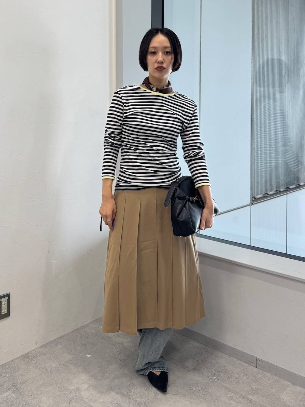ブルー系のデニムパンツ、ブラック系のショルダーバッグ、ブラック系のサンダルを着用したレディースの夏コーディネートの5枚目の写真