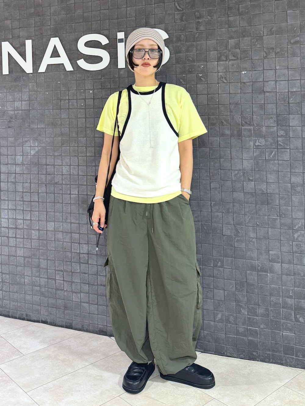 イエロー系のTシャツ/カットソー、ホワイト系のニットキャップ/ビーニーを着用したレディースの夏コーディネートの4枚目の写真