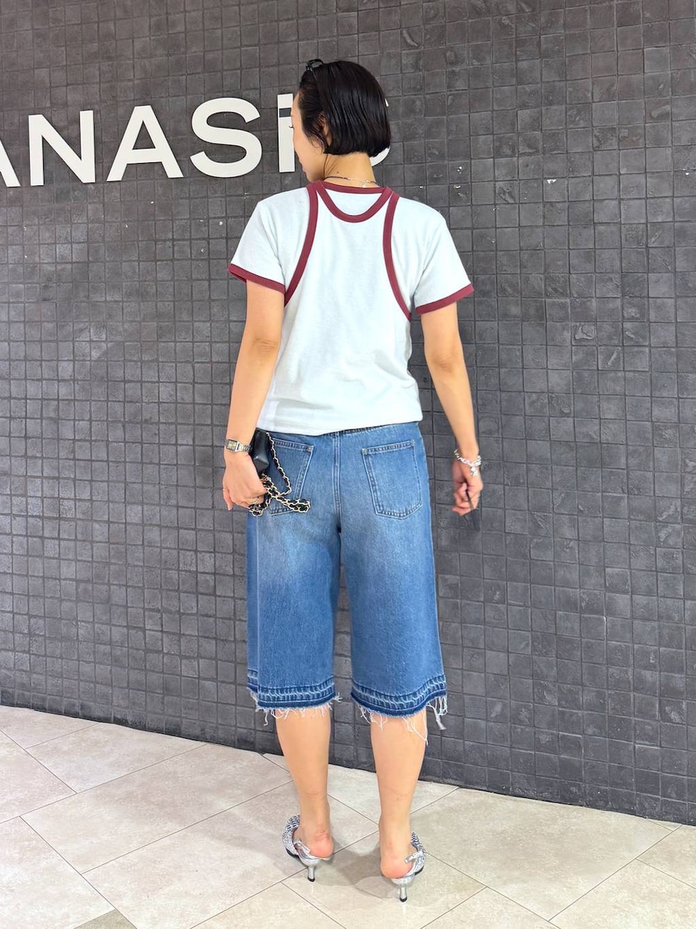 ブルー系のデニムパンツ、シルバー系のパンプスを着用したレディースの夏コーディネートの4枚目の写真